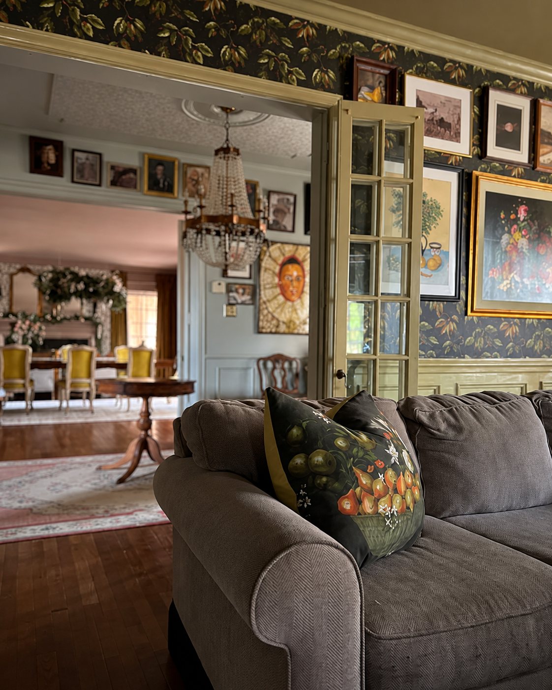 Living room opening to a dining room, walls hung with framed art